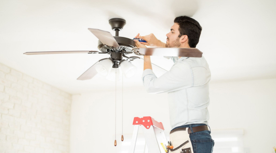 Electrician installing ceiling fan