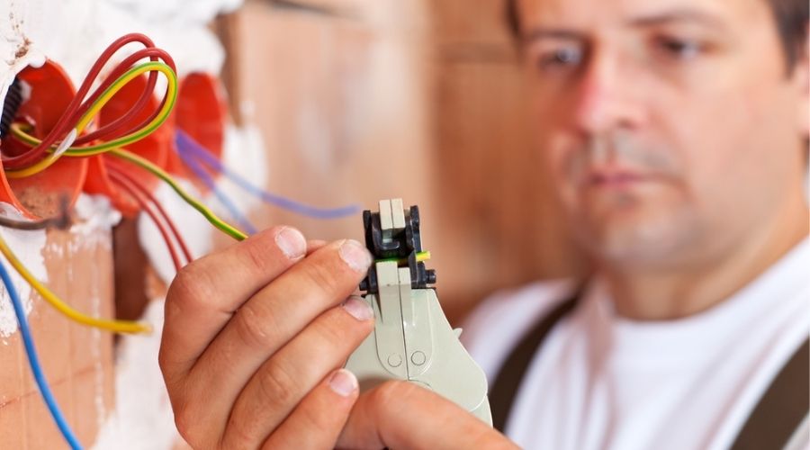 how to become an electrician in VA - electrician working on socket