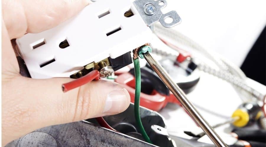 Close up of an electrician installing a wall outlet