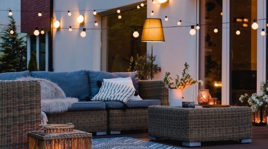 A furnished patio with string lights and outdoor lamps.
