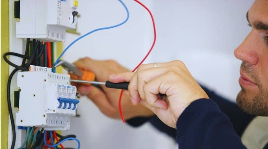 An electrician working on a circuit breaker.