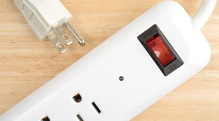 A white surge protector on a light wood background