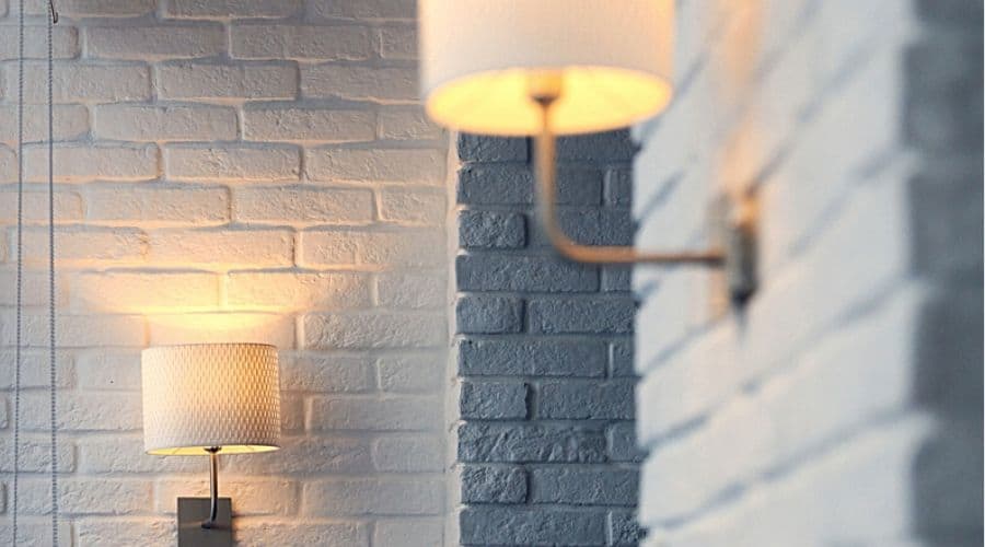 Two outdoor wall lamps on white brick