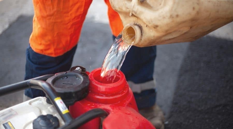 Gasoline being poured from a barrel into a generator