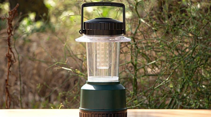 A modern camping lamp against a forest background