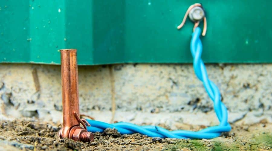 Close-up of a grounding wire connected to an outdoor generator