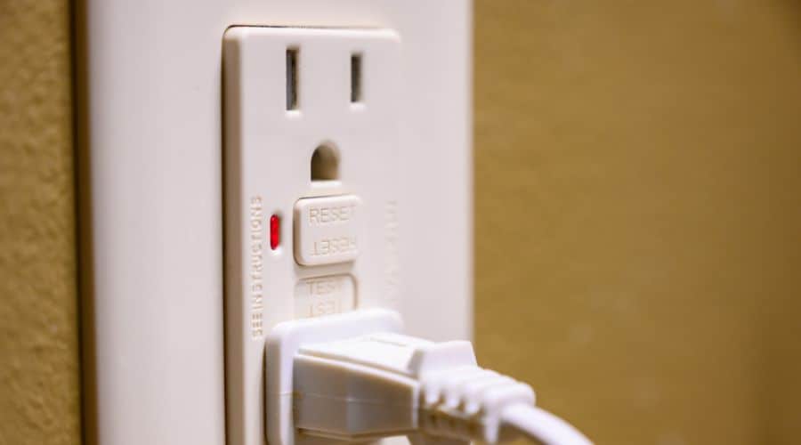 a white GFCI outlet with a plug in it
