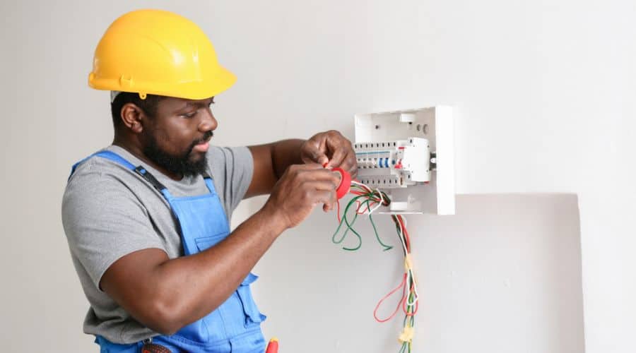 an electrician works on a circuit breaker
