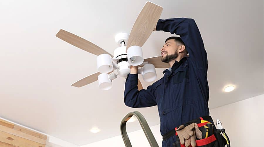 a professional electrician installing a ceiling fan
