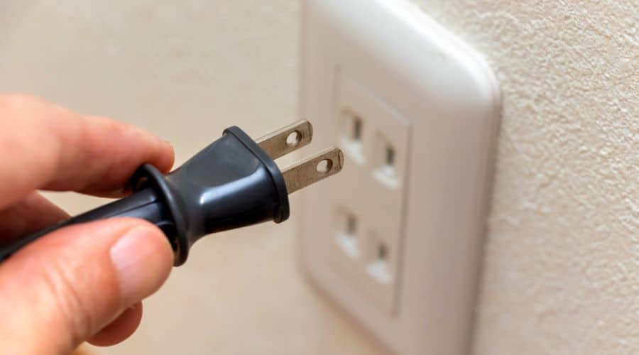 close up of a plug near an ungrounded electrical outlet