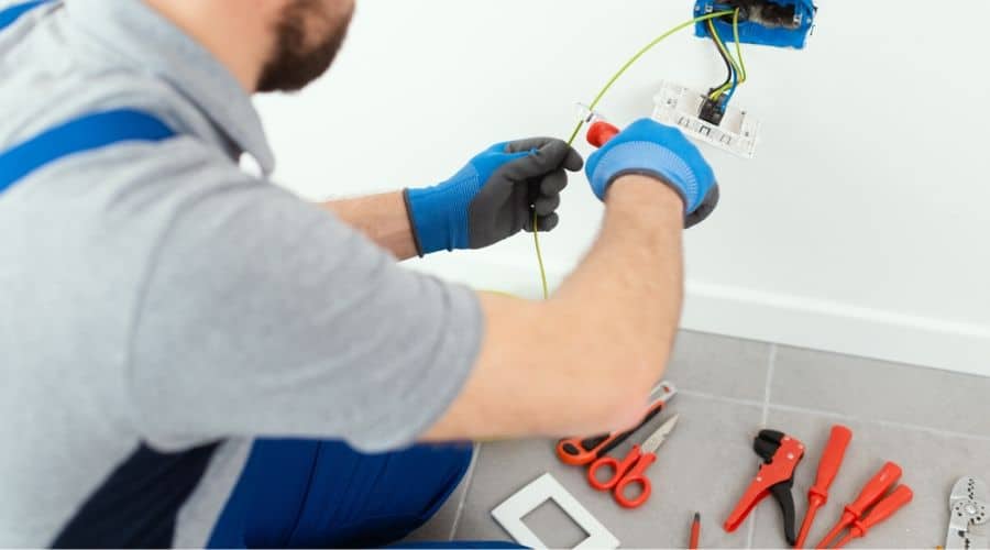 an electrician working on a gfci outlet