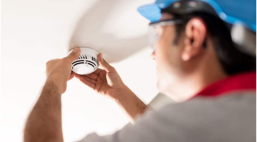 an electrician checking a smoke detector